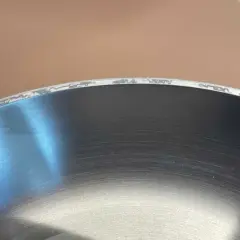 Widoczne przebarwienia na krawędzi stalowej patelni. Dowiedz się, jak usunąć przebarwienia na stali nierdzewnej i przywrócić jej blask.