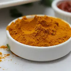 Jasnożółta kurkuma w proszku w białej miseczce, idealna do curry, zup i napojów. Kurkuma do czego? Do zdrowia i smaku!
