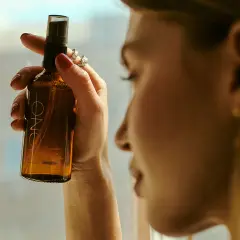 Kobieta trzyma buteleczkę z mgiełką. Czy cetearyl alcohol to składnik tej mgiełki?