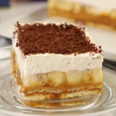 Pyszne ciasto bez pieczenia z bananami, karmelem i bitą śmietaną, posypane czekoladą. Idealne na deser.