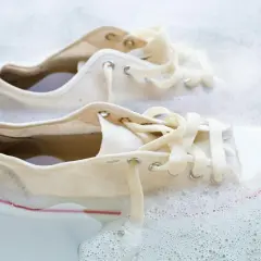 Białe trampki w pianie, gotowe do czyszczenia.