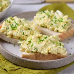 Pyszna pasta jajeczna ze szczypiorkiem na kromkach chleba. Idealna na śniadanie lub przekąskę.