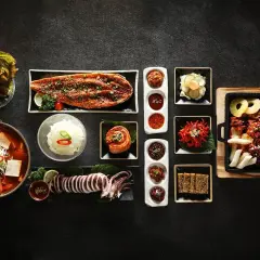 Pyszne przekąski na ognisko: grillowana ryba, kalmar, kimchi, zupa tofu i inne koreańskie smakołyki.