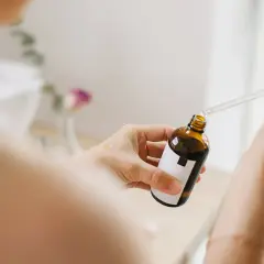 Kobieta aplikuje serum z pipetką na dłoń. Bezpieczny niacynamid w ciąży to klucz do zdrowej skóry.