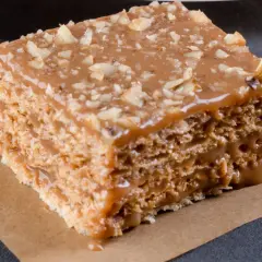 Warstwowe wafle z kremem kajmakowym, posypane orzechami. Pyszny deser, który rozpływa się w ustach.