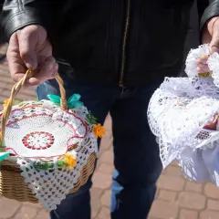 Dwie ozdobne koszyczki do święconki, jeden z koronką i kwiatkami, drugi przykryty białą tkaniną.