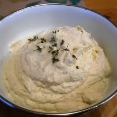 Puszysta pasta jajeczna z chrzanem, udekorowana gałązkami tymianku, w białej misce. Idealna na kanapki.