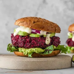 Pyszny burger z buraka z awokado, czerwoną cebulą i kremowym sosem. Idealna wegetariańska alternatywa.