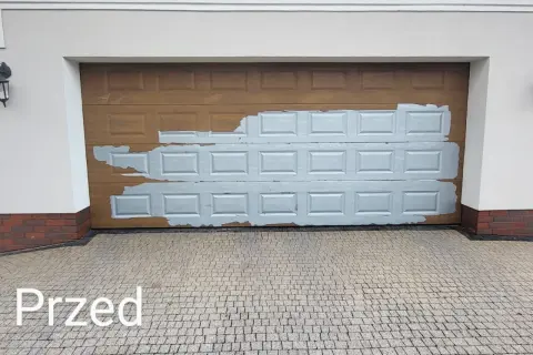 Brama garażowa w trakcie wymiany okleiny. Widoczna stara, brązowa okleina i fragmenty nowej, szarej.