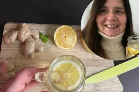 Kobieta przygotowuje orzeźwiającą wodę z cytryną i imbirem. Na desce leżą świeże korzenie imbiru i plaster cytryny.
