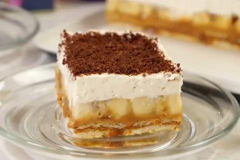 Pyszne ciasto bez pieczenia z bananami, karmelem i bitą śmietaną, posypane czekoladą. Idealne na deser.