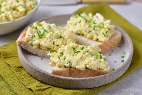 Pyszna pasta jajeczna ze szczypiorkiem na kromkach chleba. Idealna na śniadanie lub przekąskę.