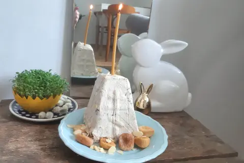 Nowoczesne potrawy wielkanocne: pyszna pascha z bakaliami, świeża zielenina i ozdobne zajączki.