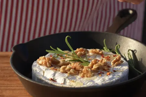 Ser camembert z orzechami i rozmarynem w patelni, idealny na szybkie przekąski na grilla.