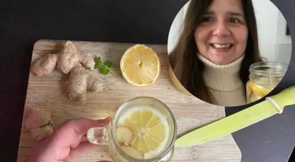 Kobieta przygotowuje orzeźwiającą wodę z cytryną i imbirem. Na desce leżą świeże korzenie imbiru i plaster cytryny.