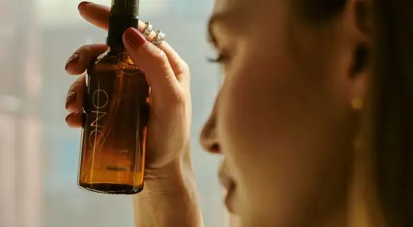Kobieta trzyma buteleczkę z mgiełką. Czy cetearyl alcohol to składnik tej mgiełki?