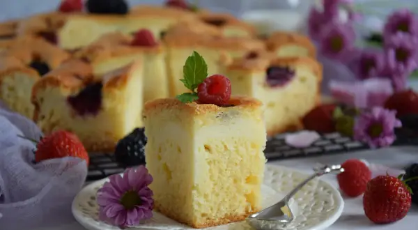 Szybkie ciasto z twarogiem i owocami leśnymi, udekorowane maliną i miętą. Idealne na deser.