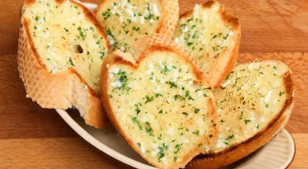 Chrupiące grzanki z piekarnika, posypane czosnkiem i natką pietruszki, kuszą swoim aromatem. Idealne jako dodatek do zupy lub samodzielna przekąska.