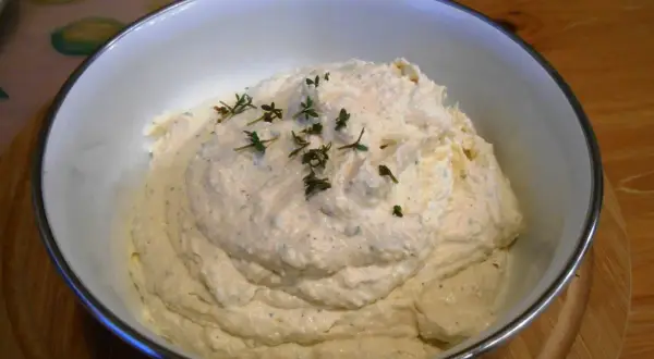 Puszysta pasta jajeczna z chrzanem, udekorowana gałązkami tymianku, w białej misce. Idealna na kanapki.