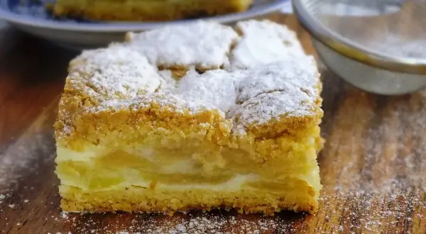 Pyszna szarlotka z kisielem, posypana cukrem pudrem, kusi swoim wyglądem.