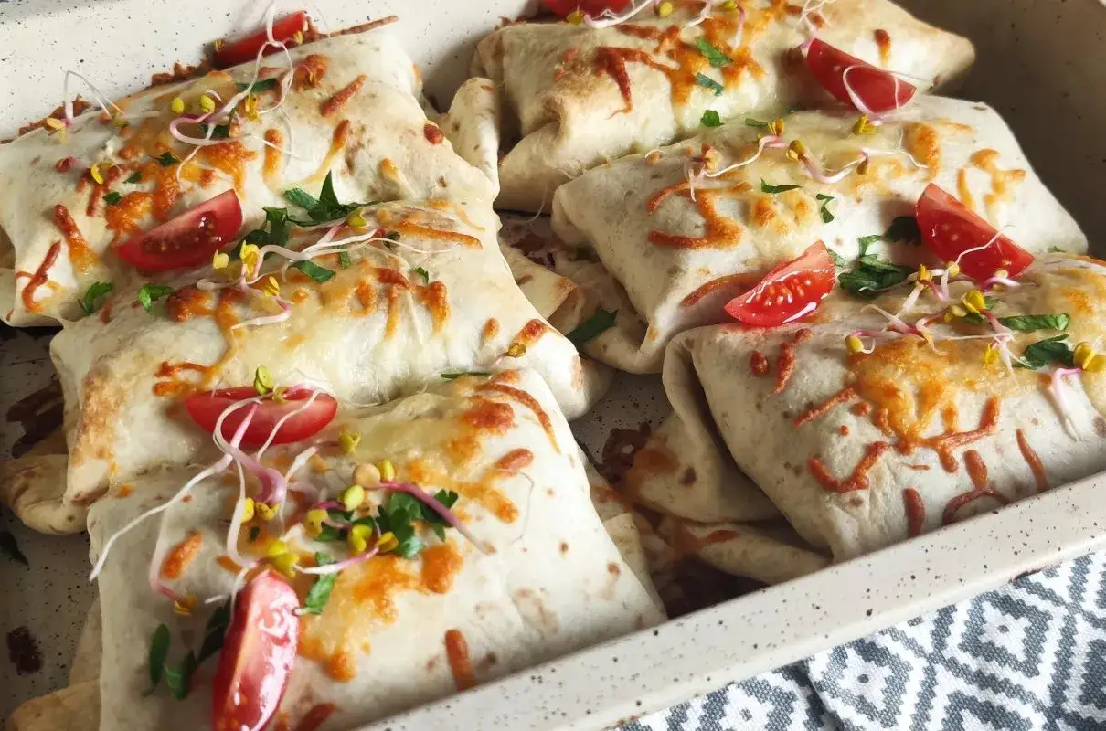 Pyszna tortilla na ciepło, zapieczona z serem, pomidorkami i kiełkami. Idealna na szybki obiad.