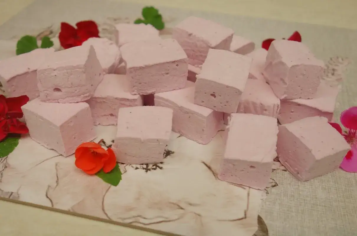 R&oacute;żowe pianki marshmallow, idealne do domowego przepisu. Delikatne, puszyste i słodkie, ozdobione kwiatami.