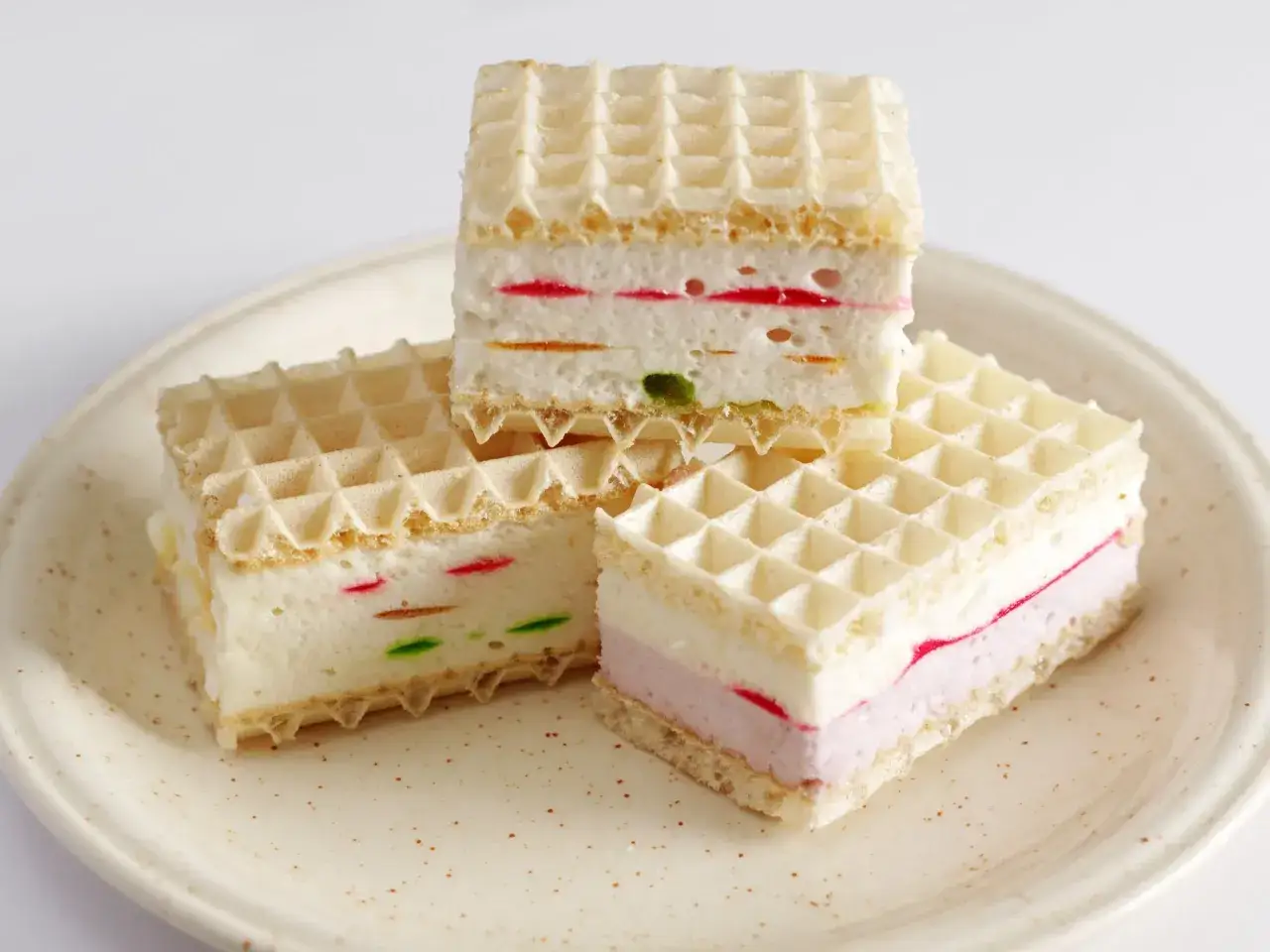 Wafle przekładane kremem śmietanowym z kolorowymi kawałkami galaretki. Idealne na deser, gdy szukasz prostego przepisu na wafle z galaretką i śmietaną.