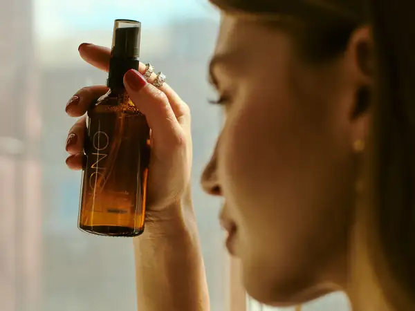 Kobieta trzyma buteleczkę z mgiełką. Czy cetearyl alcohol to składnik tej mgiełki?