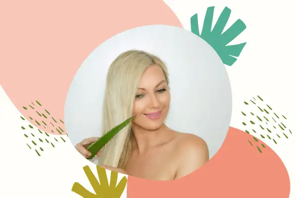 Blondynka z uśmiechem dotyka swoich włosów liściem aloesu, który jest naturalnym kosmetykiem do pielęgnacji włosów.