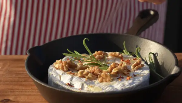 Ser camembert z orzechami i rozmarynem w patelni, idealny na szybkie przekąski na grilla.